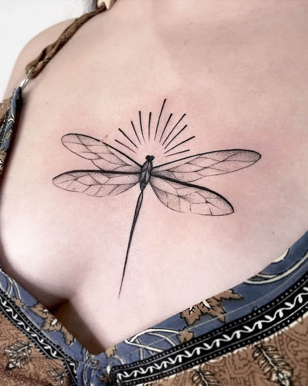 Glowing dragonfly chest tattoo by @tatuarisa