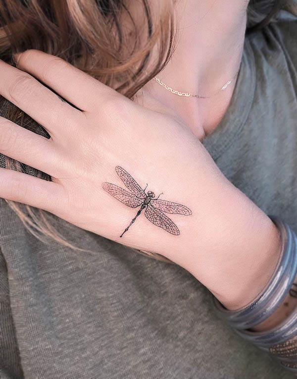 Sophisticated dragonfly hand tattoo by @mar__negro